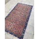 Tapis fleuri ancien sur fond rouge pastel