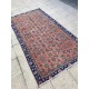 Tapis fleuri ancien sur fond rouge pastel