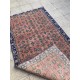 Tapis fleuri ancien sur fond rouge pastel