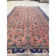 Tapis fleuri ancien sur fond rouge pastel