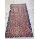 Tapis fleuri ancien sur fond rouge pastel